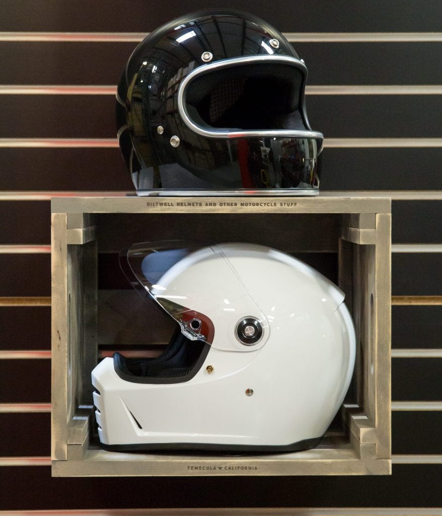 custom branded retail display for helmets - weathered with metal accents and furnishings - black helmet and white helmet wall mounted wooden retail display